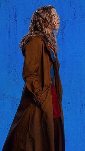 Woman In Superman Costume With Headphones And Trench Coat GIF