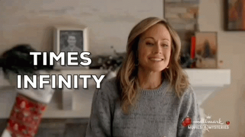 Woman In Sweater Smiling By Fireplace Times Infinity GIF
