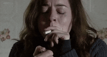 Woman In Sweater Smoking Cigarette GIF