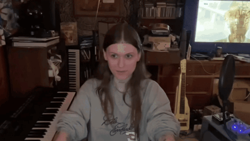 Woman in Sweatshirt Saying A Playing Keyboard