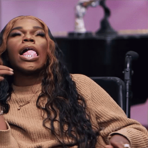 Woman In Tan Sweater Sticking Out Tongue In Wheelchair GIF