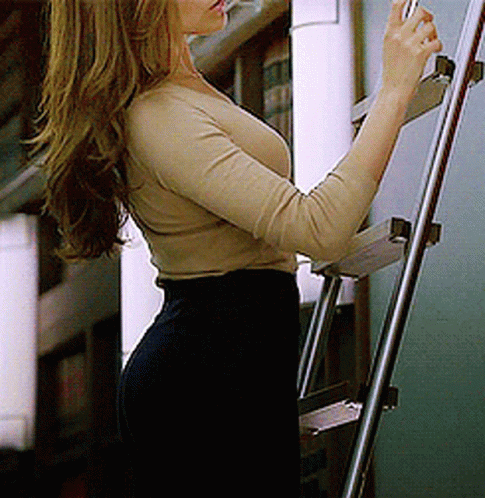 Woman in Tan Top and Black Pants on Ladder