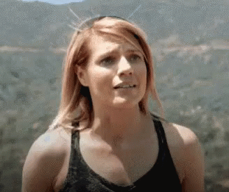 Woman In Tank Top Standing In Front Of Mountain GIF