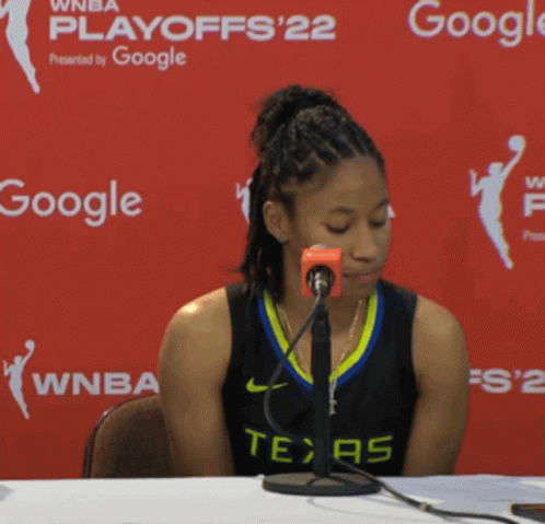 Woman in Texas Jersey Sitting at Table with Google Sign