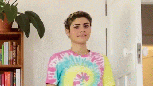 Woman in Tie Dye Shirt Standing in Front of Door