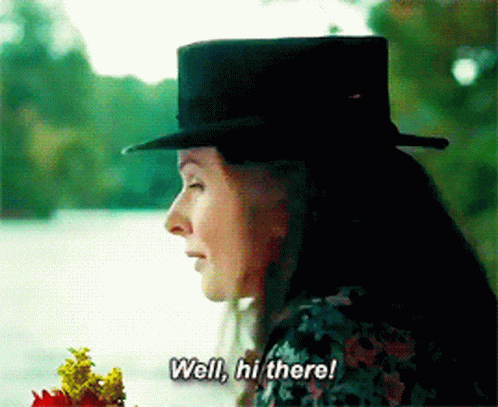 Woman In Top Hat Holding Flowers GIF
