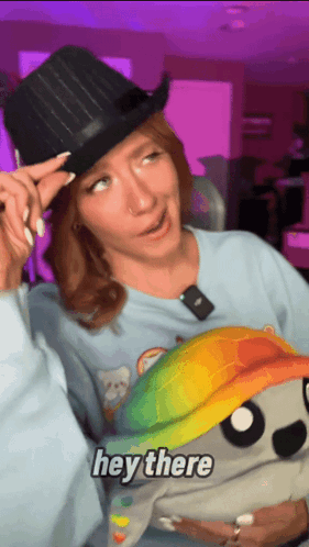 Woman In Top Hat Holding Hey There Stuffed Animal GIF