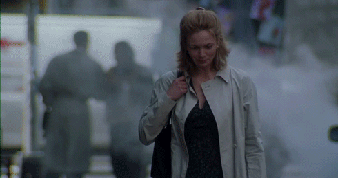 Woman in Trench Coat Walking Down Street