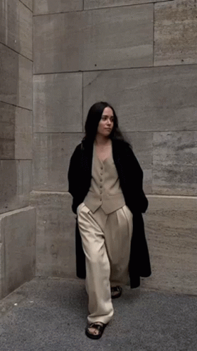 Woman In Vest And Pants Walking On Sidewalk GIF