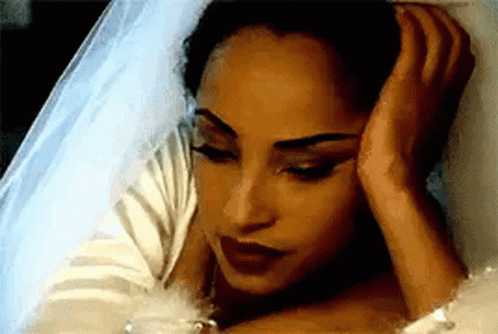 Woman in Wedding Dress Laying in Bed With Hand on Head