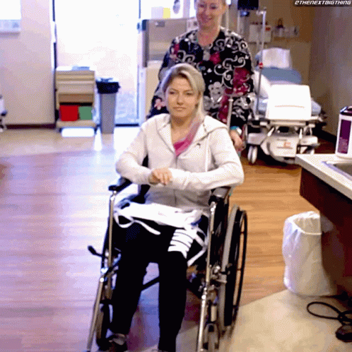 Woman In Wheelchair Pushed By Nurse Saying The Next Thing GIF