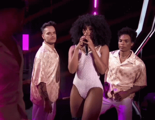 Woman in White Bodysuit Singing into Microphone
