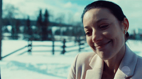Woman in White Coat Smiling in Snow