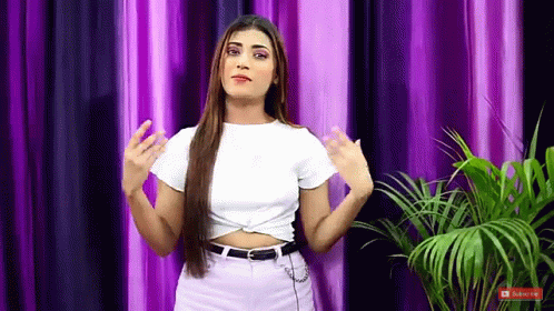 Woman in White Crop Top and Purple Jeans with Curtain and Palm