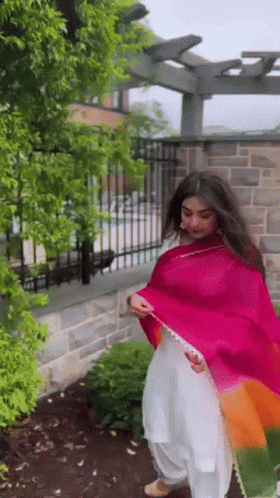 Woman in White Dress and Pink Shawl by Fence