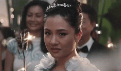 Woman in White Dress and Tiara in Front of Group
