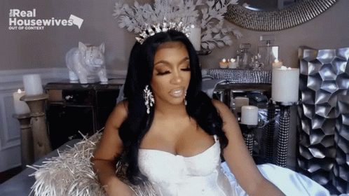 Woman In White Dress And Tiara With Real Housewives Sign GIF