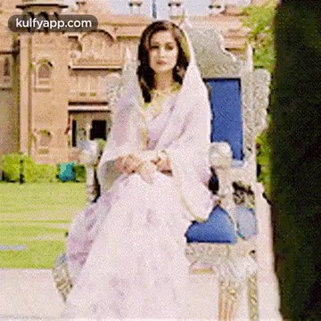 Woman in White Dress and Veil Sitting on Throne