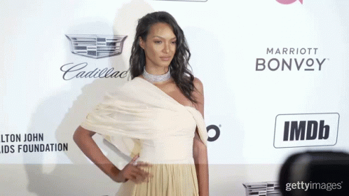 Woman In White Dress By Cadillac And Marriott Bonvoy Sign GIF