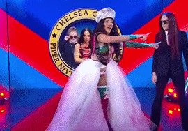 Woman in White Dress Dancing on Red Carpet in Front of Chelsea Sign