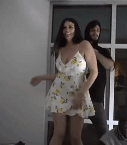 Woman In White Dress Dancing With Man In Hoodie GIF