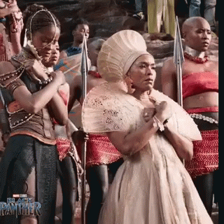 Woman In White Dress Holding Fan With Spear Holders GIF