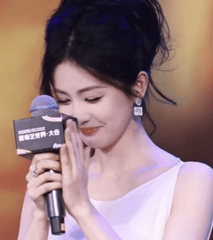 Woman in White Dress Holding Rode Microphone