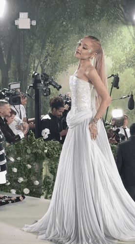 Woman in White Dress in Front of Cameras
