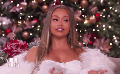Woman In White Dress In Front Of Christmas Tree GIF