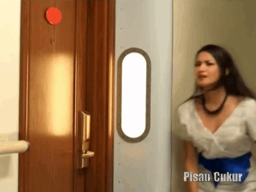 Woman in White Dress in Front of Pisau Ukur Door