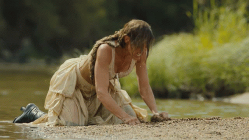 Woman in White Dress Kneeling by River