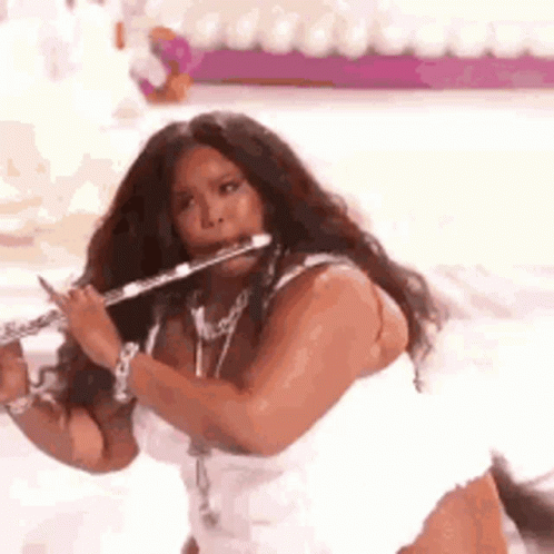 Woman in White Dress Playing Flute on Stage