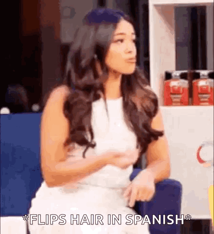 Woman In White Dress Saying Flips Hair In Spanish GIF