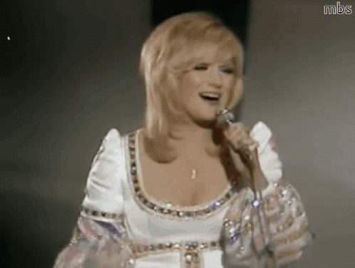 Woman in White Dress Singing Into Microphone