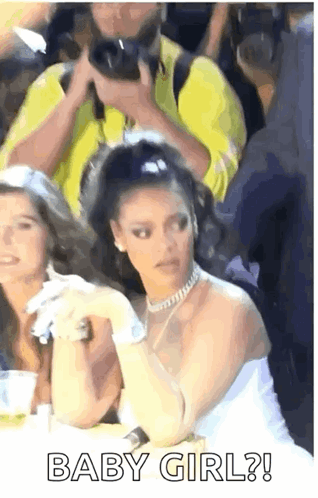 Woman in White Dress Sitting Among Crowd