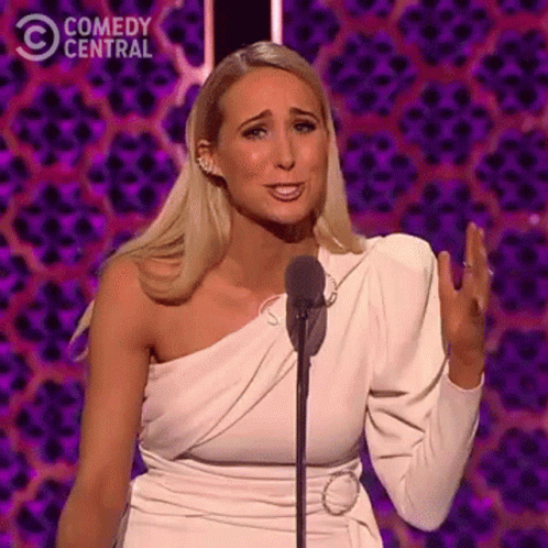 Woman in White Dress Speaking Into Microphone
