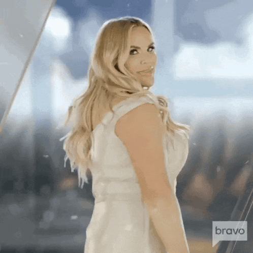 Woman in White Dress Standing Before Bravo Sign