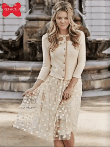 Woman in White Dress Standing in Front of Fountain With Reface App Logo