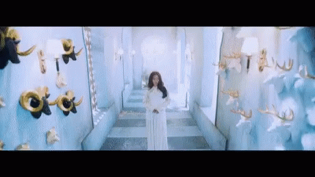 Woman In White Dress Standing In Hallway GIF