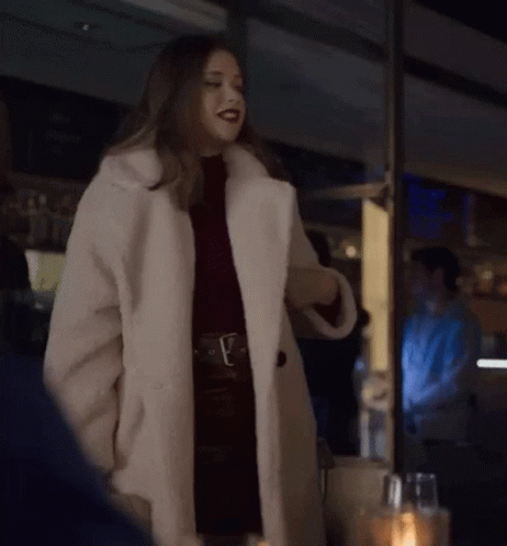 Woman in White Fur Coat by Window