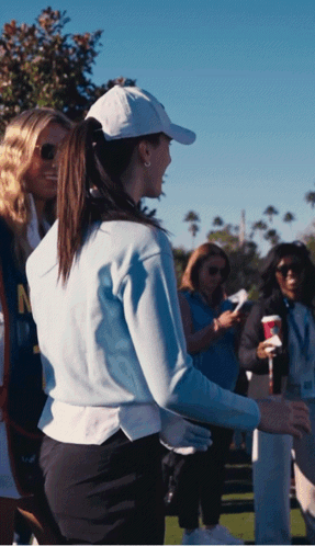 Woman in White Hat and Blue Sweater with Letter N