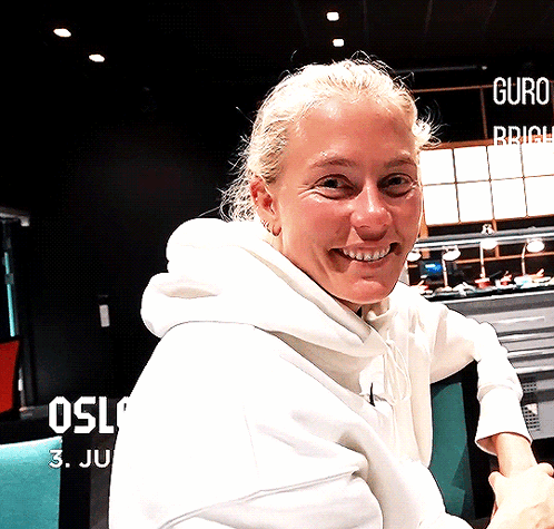 Woman in White Hoodie Smiling at Oslo Sign
