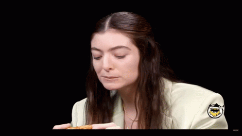 Woman In White Jacket Eating Pizza Saying Delicious Wang GIF
