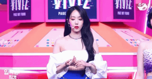 Woman in White Off-Shoulder Top and Blue Skirt on Stage With Microphone