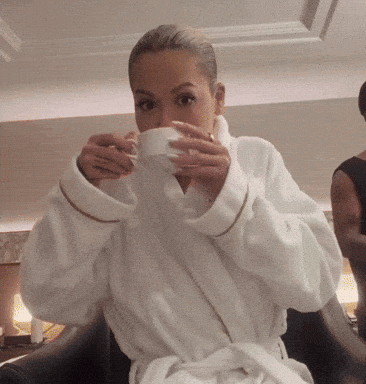 Woman In White Robe Drinking From Cup GIF