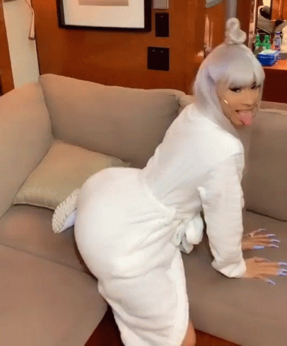 Woman in White Robe Sitting on Couch Tongue Out