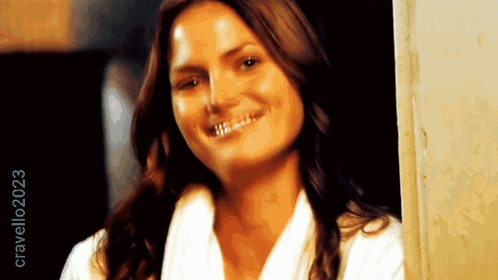 Woman In White Robe Smiling In Front Of Crave2023 Sign GIF