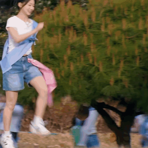 Woman in White Shirt and Blue Shorts Jumping