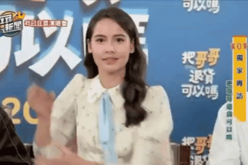 Woman in White Shirt and Blue Tie in Front of Chinese Sign