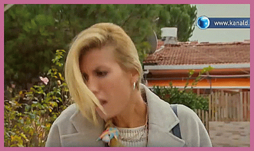 Woman in White Shirt at Table Saying e Questo